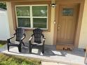 Inviting front porch features two chairs, a neutral color scheme, and a 'hello' door mat at 1913 W Saint Conrad St, Tampa, FL 33607