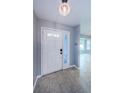 Clean entryway showcasing neutral tile flooring, a glass-paneled front door, and calming gray walls at 2609 Sunnyside Cir, Palm Harbor, FL 34684