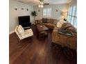 Spacious living room featuring hardwood floors, plantation shutters, a comfortable brown sectional sofa, and neutral wall color at 302 W Fern St, Tampa, FL 33604