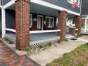 Inviting front porch with brick columns, and a cozy sitting area to enjoy the outdoors at 4106 N Central Ave, Tampa, FL 33603
