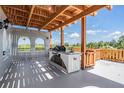 A covered outdoor kitchen area featuring a built-in grill, sink, counter space, and wooden pergola at 4710 Troydale Rd, Tampa, FL 33615