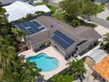 Aerial view of backyard featuring a pool, solar panels, a patio, and lush landscaping in a private backyard at 4739 114Th N St, St Petersburg, FL 33708
