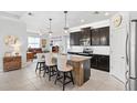 Open kitchen features dark wood cabinets, granite counters, island with seating, and stainless steel appliances at 537 Ocean Spray Dr, Ruskin, FL 33570