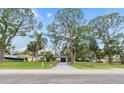 Street view of the charming single-story home with tropical landscaping at 5614 Bay Boulevard, Port Richey, FL 34668