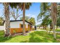 Angle view of the side of the charming single-story home featuring tropical landscaping at 5614 Bay Boulevard, Port Richey, FL 34668