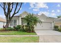 Inviting single-Gathering home with a well-maintained lawn, beautiful landscaping, and a two-car garage at 5628 Terrain De Golf Dr, Lutz, FL 33558