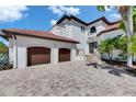 Grand Mediterranean-style home with two-car garage, paver driveway, and manicured landscaping at 6418 Bright Bay Ct, Apollo Beach, FL 33572