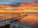 Sunset water view with long pier extending into the ocean at 6418 Bright Bay Ct, Apollo Beach, FL 33572
