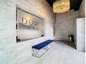 Modern lobby with elegant chandelier, tile walls, and blue seating benches in the Domus Urbana building at 644 3Rd S Ave # 402, St Petersburg, FL 33701