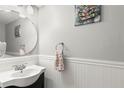 Well-lit half bathroom featuring beadboard, a round mirror, and artful accents at 6681 121St Ave # I, Largo, FL 33773