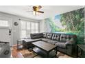 Cozy living room featuring wood-look flooring, a ceiling fan, and a scenic mural at 6681 121St Ave # I, Largo, FL 33773
