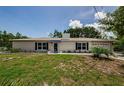 Charming single-story white brick home featuring blue shutters and a neatly kept lawn at 7332 Janczlik Dr, New Port Richey, FL 34652