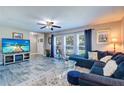 Bright living room featuring a comfortable blue sectional sofa, stylish decor, and large windows at 8289 136Th St, Seminole, FL 33776