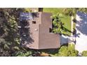 Aerial view shows roof, driveway, landscaping and proximity to surrounding trees at 852 Village Way, Palm Harbor, FL 34683