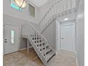 Bright entryway with tile floors, white staircase, and natural light at 852 Village Way, Palm Harbor, FL 34683