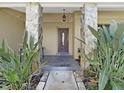 Inviting front porch with stone pillars and decorative plants at 852 Village Way, Palm Harbor, FL 34683