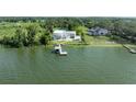 Waterfront property featuring a modern home with a pool, private dock, and stunning lake views from above at 11313 Knights Griffin Rd, Thonotosassa, FL 33592