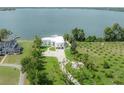 Expansive aerial view showcasing the modern waterfront home with a private dock and lush green surroundings at 11313 Knights Griffin Rd, Thonotosassa, FL 33592