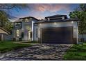Exterior elevation of a modern house with a driveway, garage and manicured lawn at 1213 E Lemon St, Tarpon Springs, FL 34689