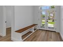 Bright foyer featuring wood-look floors, a built-in bench, and large windows at 1213 E Lemon St, Tarpon Springs, FL 34689