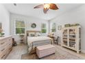 Cozy bedroom with a decorative ceiling fan, wood-look floors, neutral decor, and bright natural light at 1237 Windy Bay Shl, Tarpon Springs, FL 34689