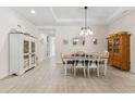 Bright dining room with neutral tile flooring, a tray ceiling, a farmhouse-style table, and decorative furnishings at 1237 Windy Bay Shl, Tarpon Springs, FL 34689