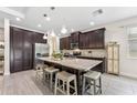Spacious kitchen featuring a marble island, stainless steel appliances, dark cabinets, and pendant lighting at 1237 Windy Bay Shl, Tarpon Springs, FL 34689
