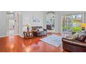 Warm living room with hardwood floors, leather furniture and sliding doors to the outdoor lanai at 12801 Stanwyck Cir, Tampa, FL 33626