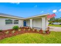 Welcoming front entrance with a bright blue door and freshly mulched garden beds at 12879 112Th St, Largo, FL 33778