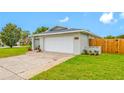 Garage and front yard featuring lawn and garden beds with an American flag at 12879 112Th St, Largo, FL 33778