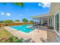 A refreshing backyard pool surrounded by a brick paver patio and screened-in lanai for outdoor relaxation at 12879 112Th St, Largo, FL 33778