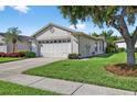 Charming one-story home with a two-car garage, beautiful landscaping, and a well-maintained lawn at 1822 Sassafras Dr, Wesley Chapel, FL 33543