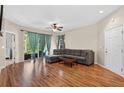 Bright living room with wood flooring, a ceiling fan, and sliding doors leading to a patio at 1822 Sassafras Dr, Wesley Chapel, FL 33543