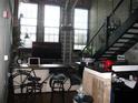 Modern living room with a bicycle used as a desk, natural light coming from large windows, and stairs at 2001 E 2Nd Ave # 27, Tampa, FL 33605