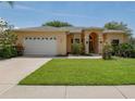 Inviting one-story home featuring a well-maintained lawn and a two-car garage with a long driveway at 2406 Dana Dr, Safety Harbor, FL 34695
