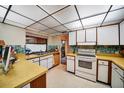 Well-lit kitchen featuring white cabinets, a window over the sink, and tiled backsplash offering a practical cooking space at 2817 Rustic Oaks Dr, Palm Harbor, FL 34684