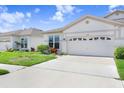 Well-maintained home with a lush green lawn and a spacious driveway at 30247 Emmetts Ct, Wesley Chapel, FL 33543