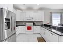 Modern kitchen with white cabinets, stainless steel appliances, and granite countertops at 30247 Emmetts Ct, Wesley Chapel, FL 33543