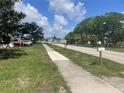 Street view with sidewalk, green trees, and homes on a sunny day at 3110 58Th N Ave, St Petersburg, FL 33714