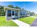 Welcoming single-story home with a cozy front porch and landscaped yard at 37812 Valencia Ave, Zephyrhills, FL 33541