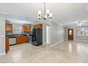 Open-concept kitchen featuring modern appliances, light tile floor, and stylish light fixtures at 4242 7Th N Ave, St Petersburg, FL 33713