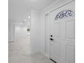 Bright foyer with marble floors, leading into an open living space and featuring a modern, decorative front door at 4313 Riviera Ct, Spring Hill, FL 34608