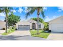 Inviting single-story home with a lush lawn and mature landscaping on a sunny day at 4407 Whitton Way, New Port Richey, FL 34653