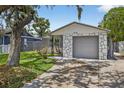 View of home showcasing its attached garage, well-kept lawn, and architectural accents adding to curb appeal at 4535 15Th S Ave, St Petersburg, FL 33711