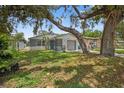 Inviting view of a single-story home with a stone exterior, complemented by lush greenery and mature trees at 4535 15Th S Ave, St Petersburg, FL 33711