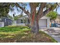 Frontal view of house featuring a stone facade, attached garage, and a mature tree enhancing its charm at 4535 15Th S Ave, St Petersburg, FL 33711