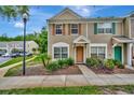 Inviting townhouse featuring a cozy front garden, stucco exterior, and decorative window shutters at 5502 Carrollwood Key Dr, Tampa, FL 33624