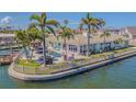 Home with waterfront access, a swimming pool, tiki bar and fenced yard with lush landscaping at 5950 Bikini N Way, St Pete Beach, FL 33706