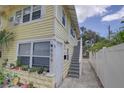 Charming yellow exterior of building with white trim and front door and stairway entrance at 659 26Th S Ave, St Petersburg, FL 33705