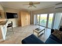 Comfortable living room featuring neutral tile floors, a murphy bed, and ample natural light at 880 Mandalay Ave # C412, Clearwater Beach, FL 33767